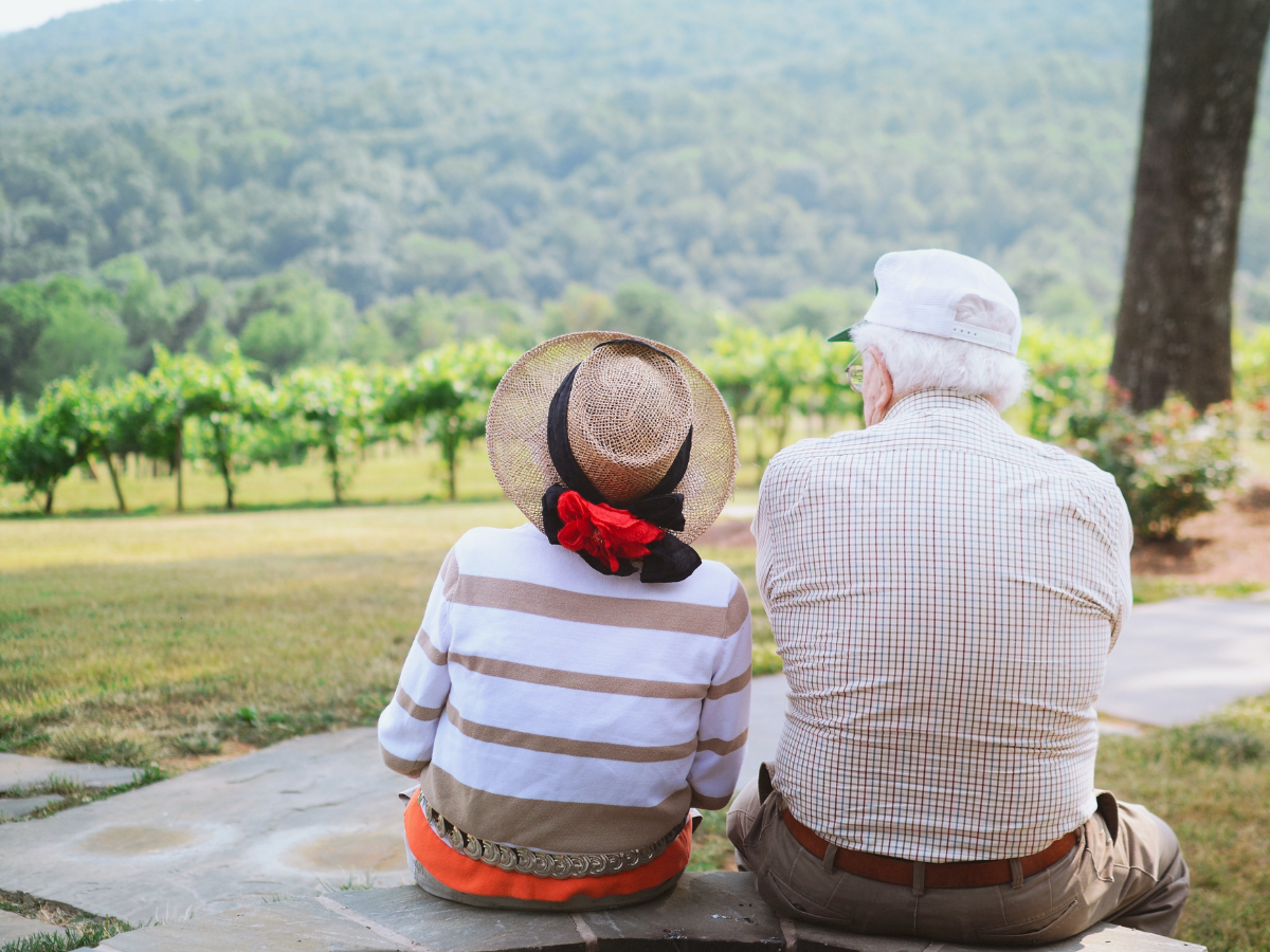 Two older people sitting together looking over a hill, symbolizing one of they ways people can celebrate the international day of older persons