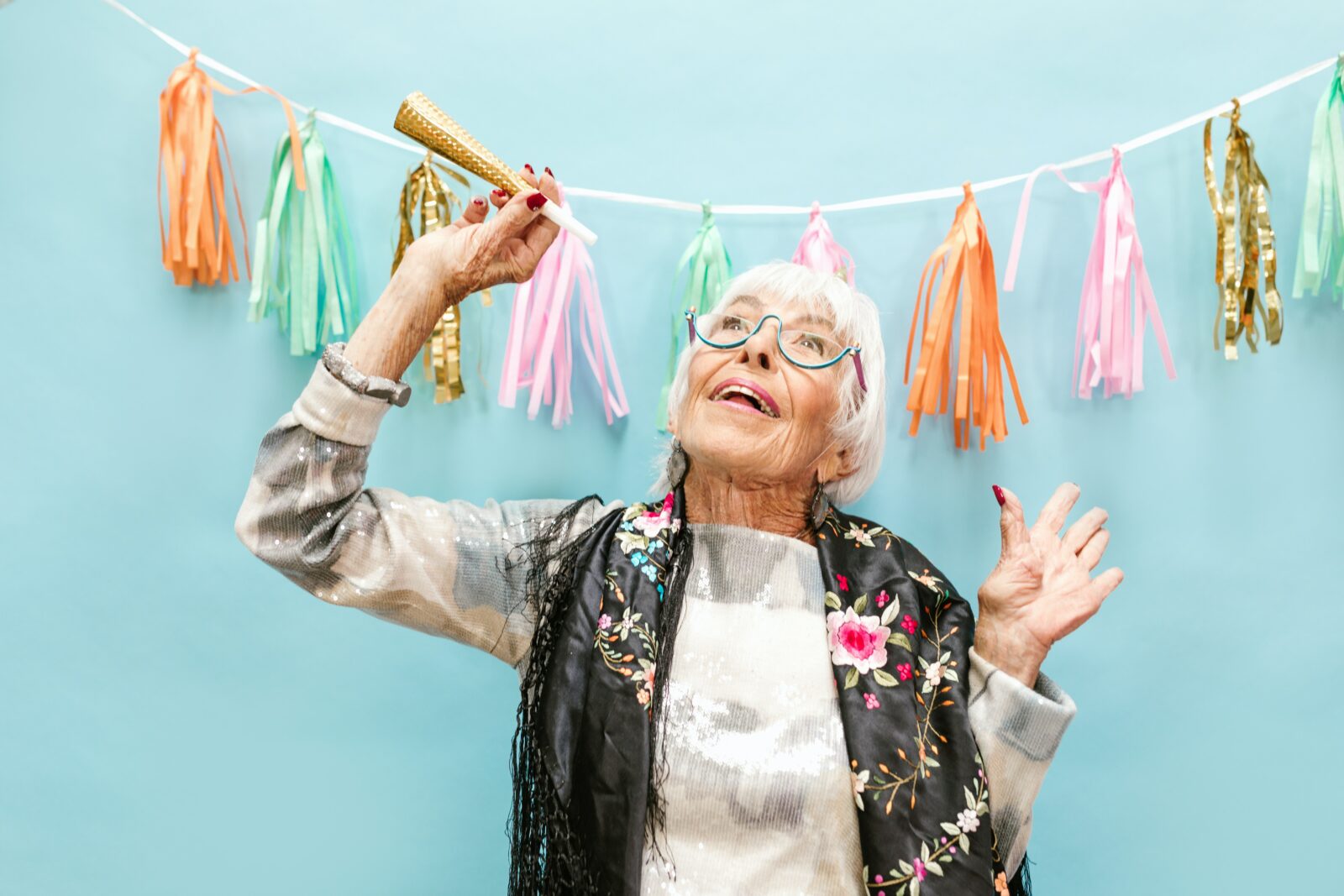 A woman with streamers behind her having fun, demonstrating independence in the home