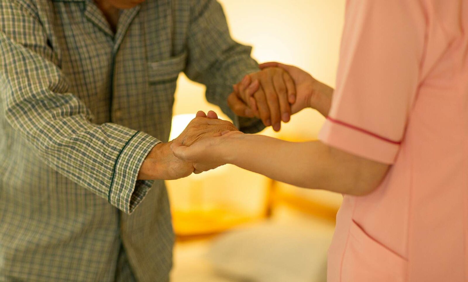 senior holding hands with caretaker